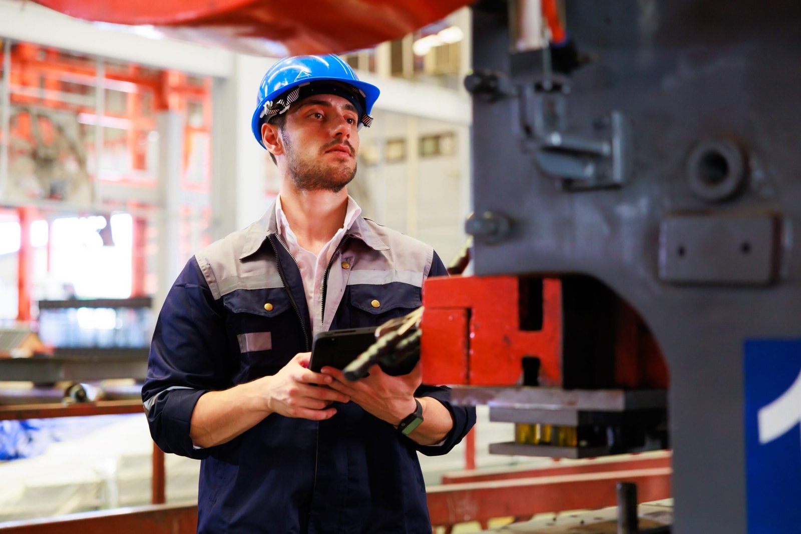 lathe and stamping metal machine. Hispanic man and Factory engineer in hard hat helmet working on digital teblet computer at Heavy Industry Manufacturing Factory.